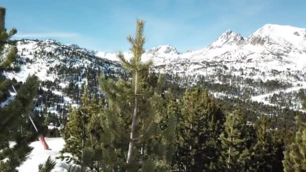 Passeio suaves subidas por pinheiros com vista para as montanhas e pistas de esqui. Estância de esqui de Grandvalira em Andorra. Magníficas montanhas nevadas e céu azul. — Vídeo de Stock