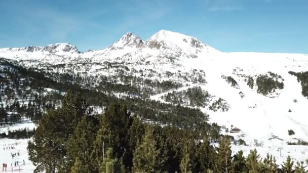 Glad bergop rijden langs pijnbomen met uitzicht op de bergen en skipistes. Skigebied Grandvalira in Andorra. Prachtige besneeuwde bergen en blauwe lucht. — Stockvideo