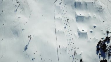Andorra 'daki Grandvalira kayak merkezindeki kayak pistleri boyunca hava manzaralı hareketlilik. Kayakçılarla kayak kaldırma. Muhteşem karlı dağlar ve mavi gökyüzü. Kış manzarası. Üst alt görünüm.