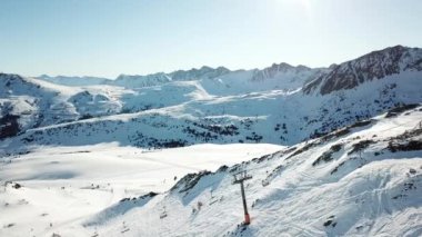 Andorra 'daki Grandvalira kayak merkezindeki kayak pistleri boyunca hava manzaralı hareketlilik. Muhteşem karlı dağlar ve mavi gökyüzü. Kış manzarası