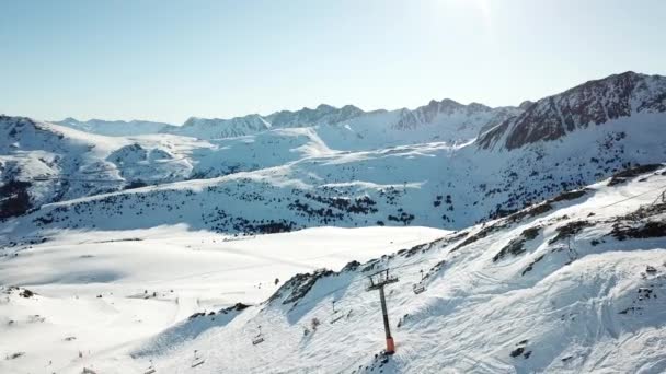 Vista aérea movimento suave ao longo das pistas de esqui na estância de esqui de Grandvalira em Andorra. Magníficas montanhas nevadas e céu azul. Paisagem inverno — Vídeo de Stock