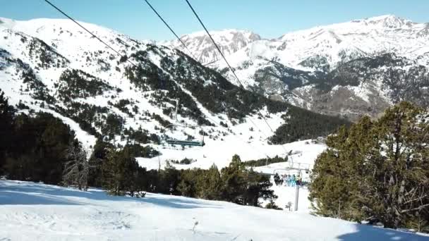 ENCAMP, ANDORRA - FEVEREIRO 16, 2019: Vista aérea movimento suave ao longo das pistas de esqui na estância de esqui de Grandvalira, em Andorra. Esquiadores escalam em um elevador de cadeira. — Vídeo de Stock