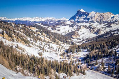 Güneşli bir kış gününde, bir sandalyeden yükselen kozalaklı orman ve dağların manzarası. Dolomites dağlarında kayak merkezi Arabba. Passo Pordoi geçidi. , İtalya