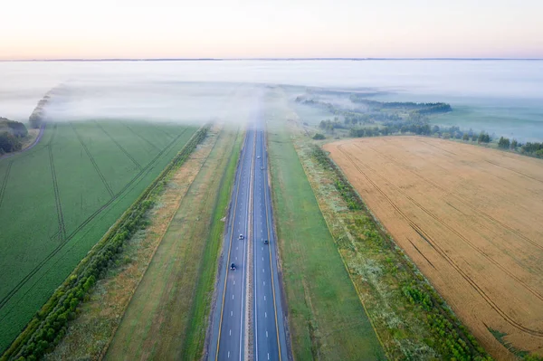Autobahn Durch Wiese Nebel Umgeben Von Wald Luftaufnahme Einer Nebelbedeckten lizenzfreie Stockbilder