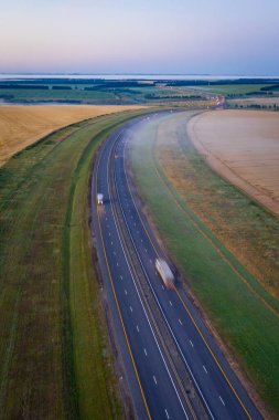 Şafakta buğday tarlaları boyunca otoyol. Yüksekten sabah manzarası. Rostov bölgesi, Rusya