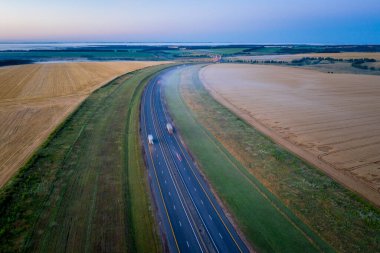 Şafakta buğday tarlaları boyunca otoyol. Yüksekten sabah manzarası. Rostov bölgesi, Rusya