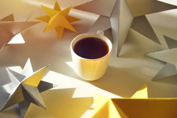 Cup of coffee with paper stars in sun ligh. Make a wish come true. A copy of space