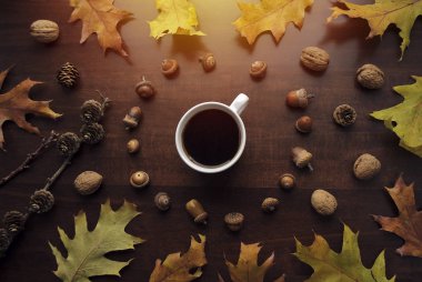 Kahve molası. Sarı sonbahar yapraklı sıcak kahve, tarla kuşu, fındık ve meşe palamudu. Sonbahar dekoru, sonbahar havası, sonbahar natürmortu. Haftasonu için kendine zaman ayırıyorsun. Üst görünüm
