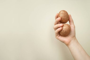 Duvarın önünde altın yumurtaları tutan kadınların minimalist görüntüsü. Metin için boşluk