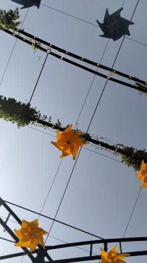 Sarı ve mavi dekoratif plastik yel değirmenleri asılmış veya caddenin yukarısındaki binalar arasında metal bir yapıda asılı duruyor. Şehir dekoru