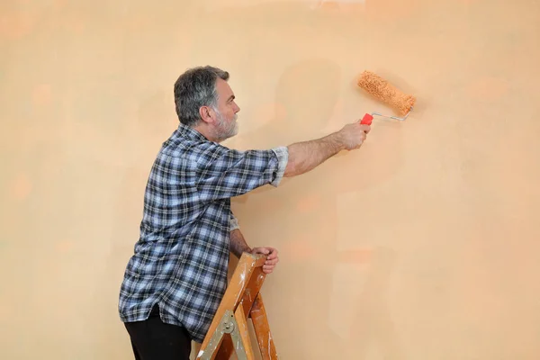 Trabajador Pintura Pared Naranja Con Rodillo Pintura Escalera — Foto de Stock