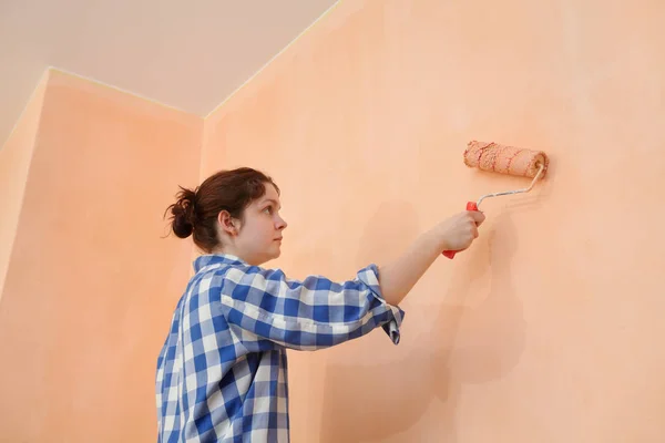 女性労働者絵画壁ペイント ローラーとオレンジ色に — ストック写真