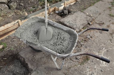 Bir el arabası içinde kürek ile beton yığını