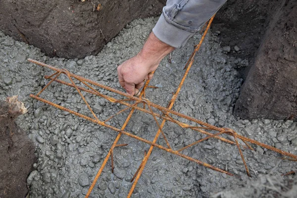 労働者が建設現場で壁で囲った基礎のコンクリート補強筋を配置すること — ストック写真
