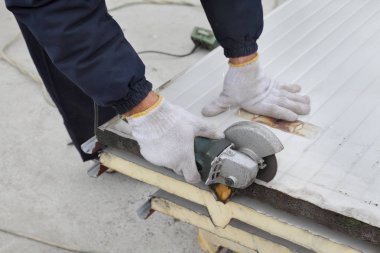 Galvanizli oluklu sandviç çatı veya duvar paneli, işçi el ve açılı taşlama aracı kesme ısı yalıtımlı