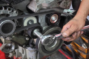 PK kemer, makaralar ve alternatör modern araba motoru, closeup el ve ratchet aracının sabitleme işçi