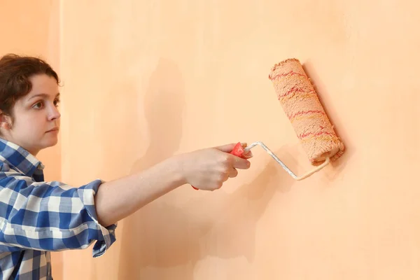 女工作者画墙壁到橙色与油漆滚筒 选择焦点在手 — 图库照片