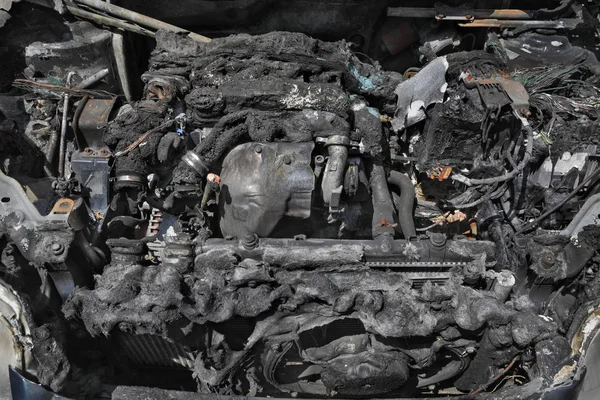 Burned and damaged car engine after fire accident