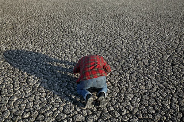Отчаянный Человек Преклоняет Колени Молится Сухой Трещине Земли После Засухи — стоковое фото