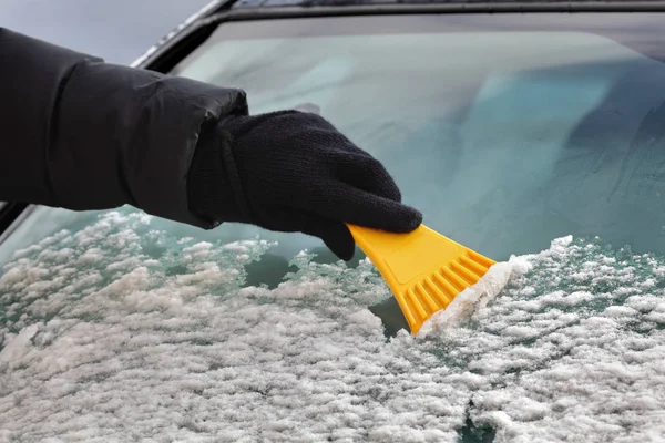 ドライバー スクレーパーを使用して車のフロント ガラスからの雪をクリーニング — ストック写真