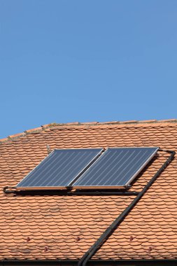 Güneş panelleri kırmızı kiremit, eski house için Isıtma, mavi gökyüzü ile su çatı