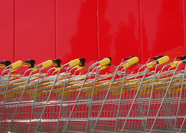 Montón Nuevos Carros Compras Brillantes Supermercado Con Pared Roja Fondo —  Fotos de Stock