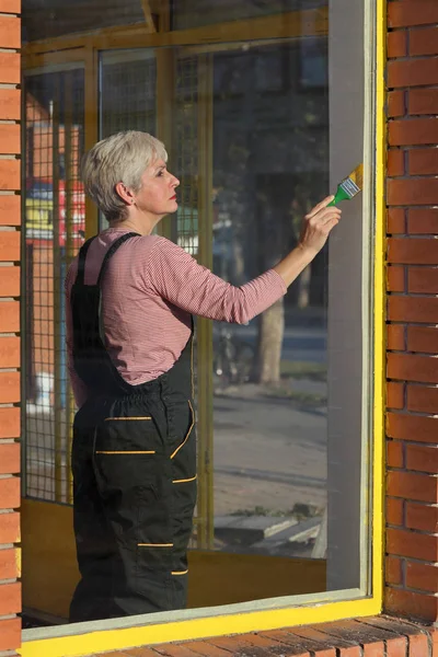 Vuxen Kvinna Metal Paint Fönstret Till Gul Färg Gamla Butik — Stockfoto