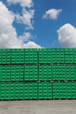 Celarevo, Sırbistan - 11 Haziran. 2017. Carlsberg Sırbistan bira fabrikası, Tuborg Bira Fabrikası, mavi gökyüzü ve bulutlar büyük depo için yeşil kasalar yığını