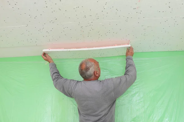 工人将发泡胶绝缘放置在房间 室内工程的天花板上 — 图库照片
