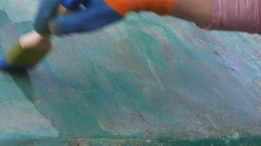 Pas dönüştürücüyü eski metal plakaya uygulayan işçiler, el ve fırça aracını kapatın