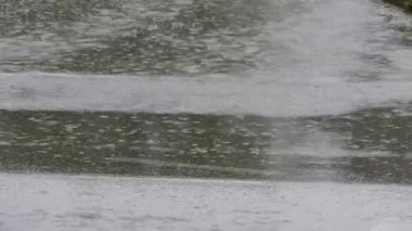 Yağmur geçen arabalar ve ışık yansıması ile ıslak asfalt yol aşağı düşen