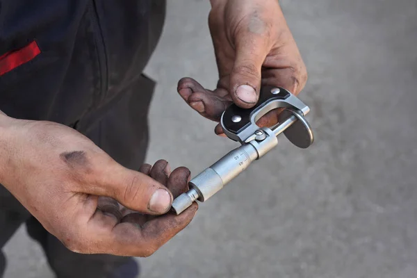 Measuring tool in mechanic hands — Stock Photo, Image
