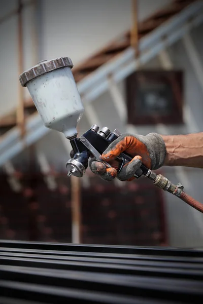 Trabalhador usando pistola de tinta para pintar metal — Fotografia de Stock