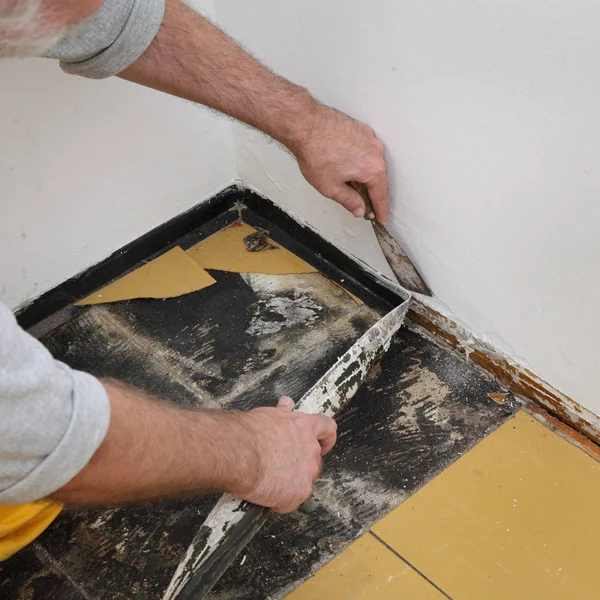 Стару вінілову плитку видаляють з підлоги в кімнаті або на кухні — стокове фото