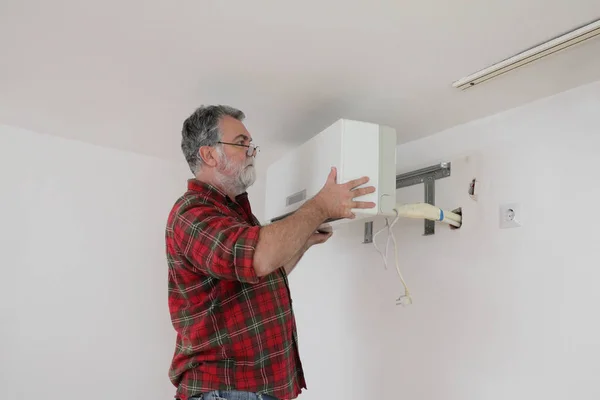 Werknemer die airconditioningapparatuur installeert — Stockfoto