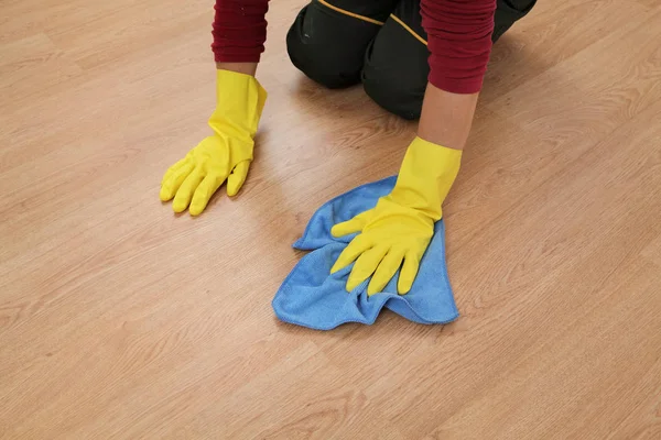Ręka w rękawicy czyszczenie laminatu podłogi — Zdjęcie stockowe