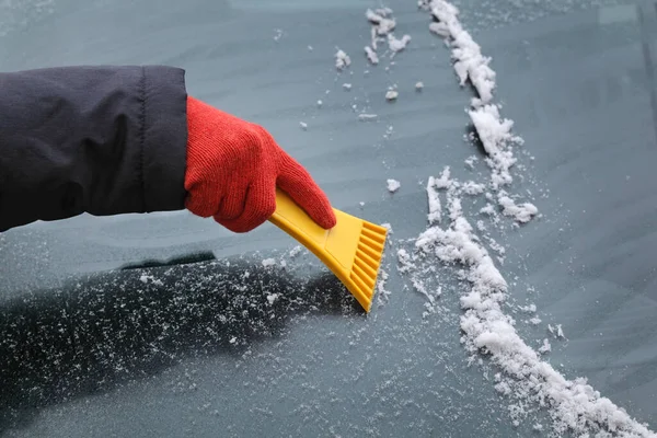 冬の風景 車のフロントガラスから手袋のスクレーピング氷の人間の手 — ストック写真