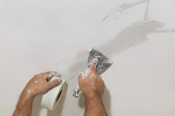 天井に亀裂を固定し 繊維メッシュの上にトロエルで石膏を広げる労働者 — ストック写真