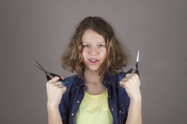 Makas ile gülümseyen güzel kıvırcık saçlı gençler kız 