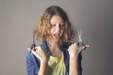 Makas ile gülümseyen güzel kıvırcık saçlı kız 