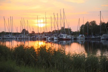 Yat ve Yelkenli Harbour yakınındaki greifswald Almanya ile düzgün ve sessiz nehir üzerinde pastell renklerde güzel gün batımı