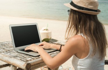 Genç kadın plajda çalışıyor. 