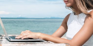 Genç kadın plajda çalışıyor. 