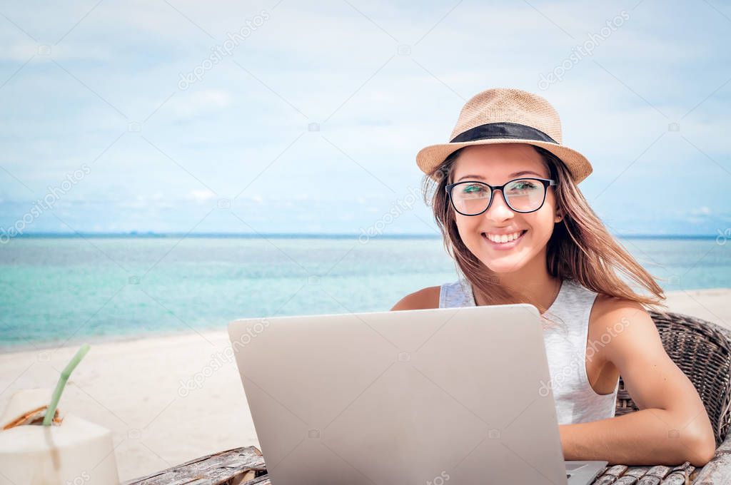 Young woman freelancer working on the beach 
