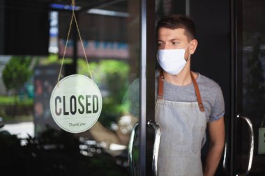 Güvenlik maskeli şef restoran kapısına yazı asıyor.. 