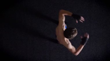 Genç beyaz üstsüz boksör yapmak sırt, omurga ısınma, en iyi atış, siyah arka plan. 50 fps