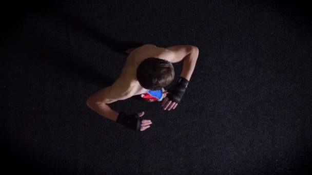 Junger kaukasischer Boxer oben ohne bei Schritten und Rücken, Wirbelsäulenaufwärmung, Top-Schuss, schwarzer Hintergrund. 50 fps — Stockvideo
