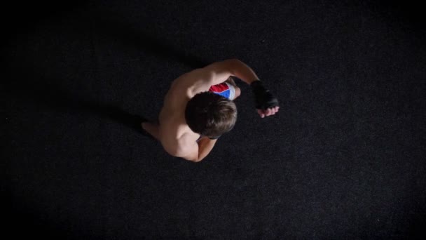 Joven boxeador topless caucásico haciendo calentamiento, golpeando, boxeo, tiro superior, fondo negro. 50 fps — Vídeos de Stock