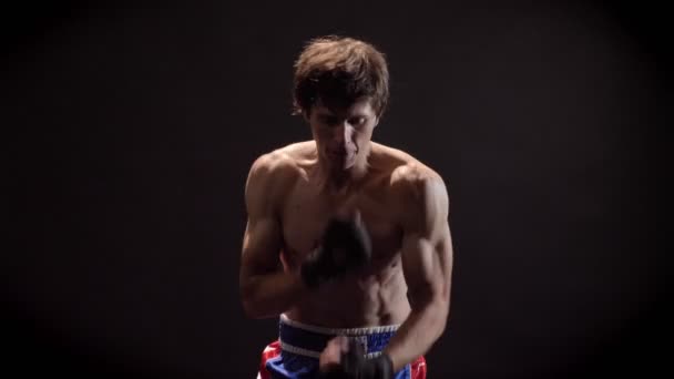 Портрет молодого кавказского топлесс-боксера, бокс, борьба с тенью, тренировка, черный фон 50 кадров в секунду — стоковое видео