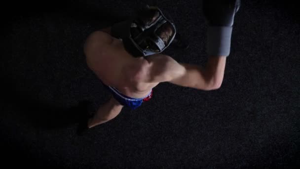 Mladý boxer kavkazské nahoře bez boxu v ochranné helmy, úder, úder, černé pozadí, horní zobrazit 50 fps — Stock video